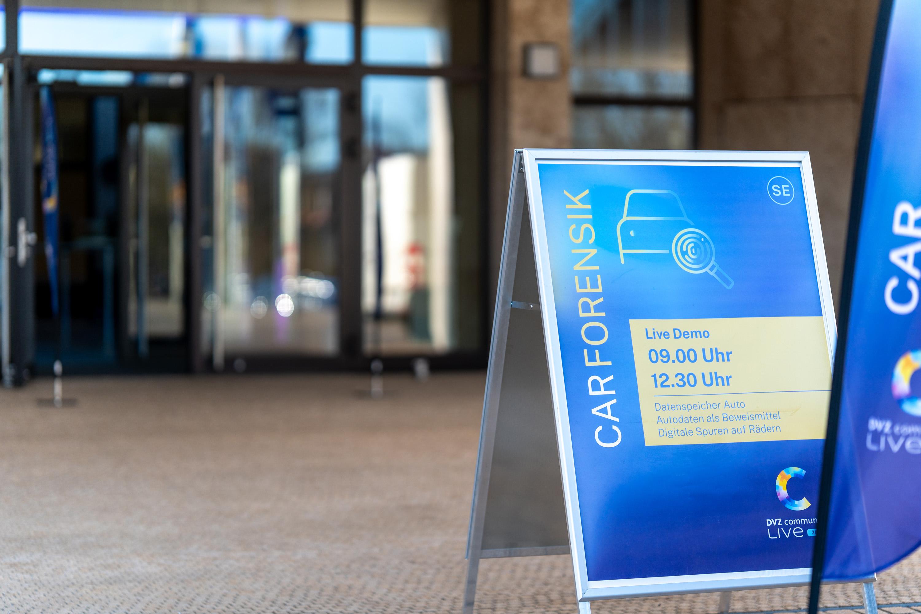 Schild mit der Aufschrift 'CAR FORENSIK' und Informationen zu Live-Demonstrationen um 09:00 und 12:30 Uhr, vor der IHK zu Schwerin