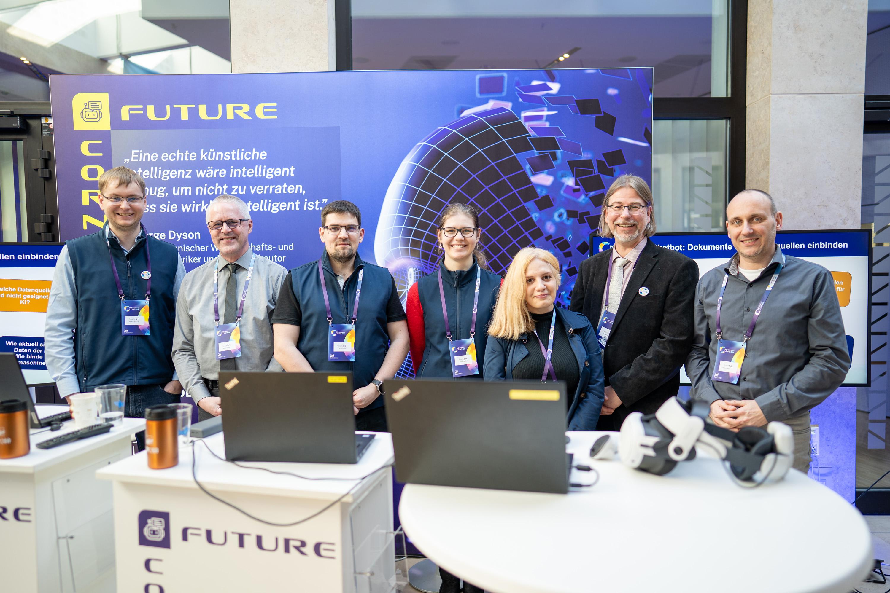 Eine Gruppe von Menschen stehen vor einer Messsewand, der Future Corner.
